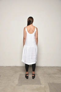 Back view of a white linen peplum dress by SIMPLY MILA, featuring a fitted bodice and flared peplum hem for a stylish look.