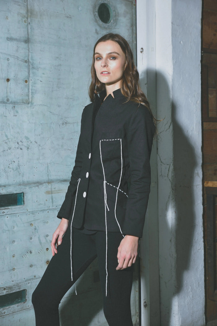 Modern women's Baste Stitch jacket by SIMPLY MILA featuring a stylish design and tailored fit, displayed on a hanger.
