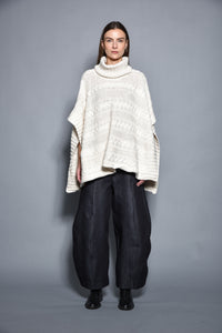 Gray cable-knit poncho by SIMPLY MILA, modern women's clothing, draped over a mannequin, showcasing cozy, stylish winter wear.