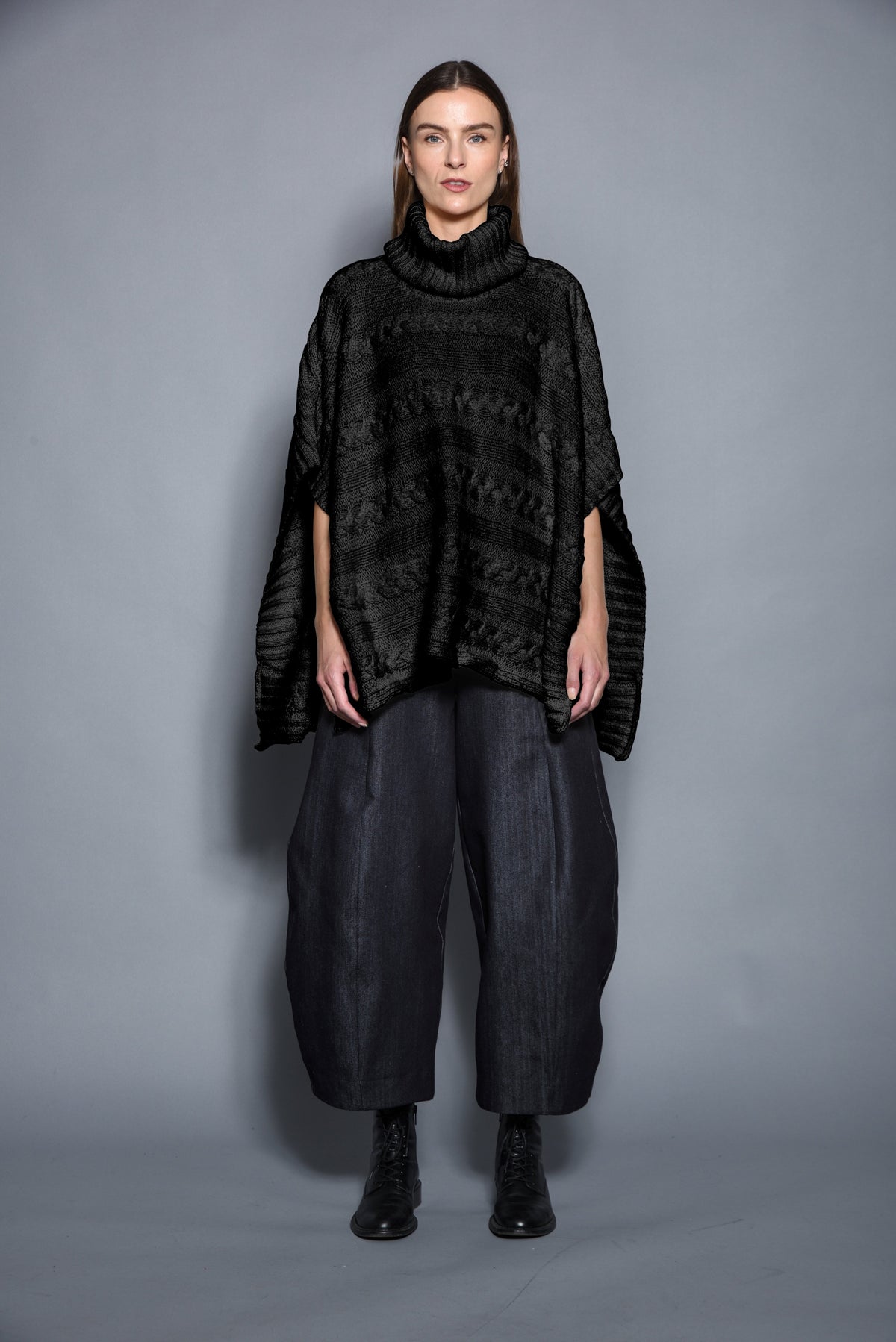 Black Cable Poncho by SIMPLY MILA, modern women's clothing, showing cozy knit fabric and relaxed fit.