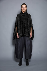 Black Cable Poncho by SIMPLY MILA, modern women's clothing, showing cozy knit fabric and relaxed fit.
