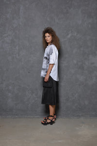 Side view of a white Stroke Boxy Shirt by SIMPLY MILA, modern women's shirt with a relaxed fit and clean design.