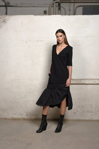 Simply Mila unbalance ruffle sweater dress in soft knit fabric, featuring ruffle details and a relaxed fit for modern women's style.