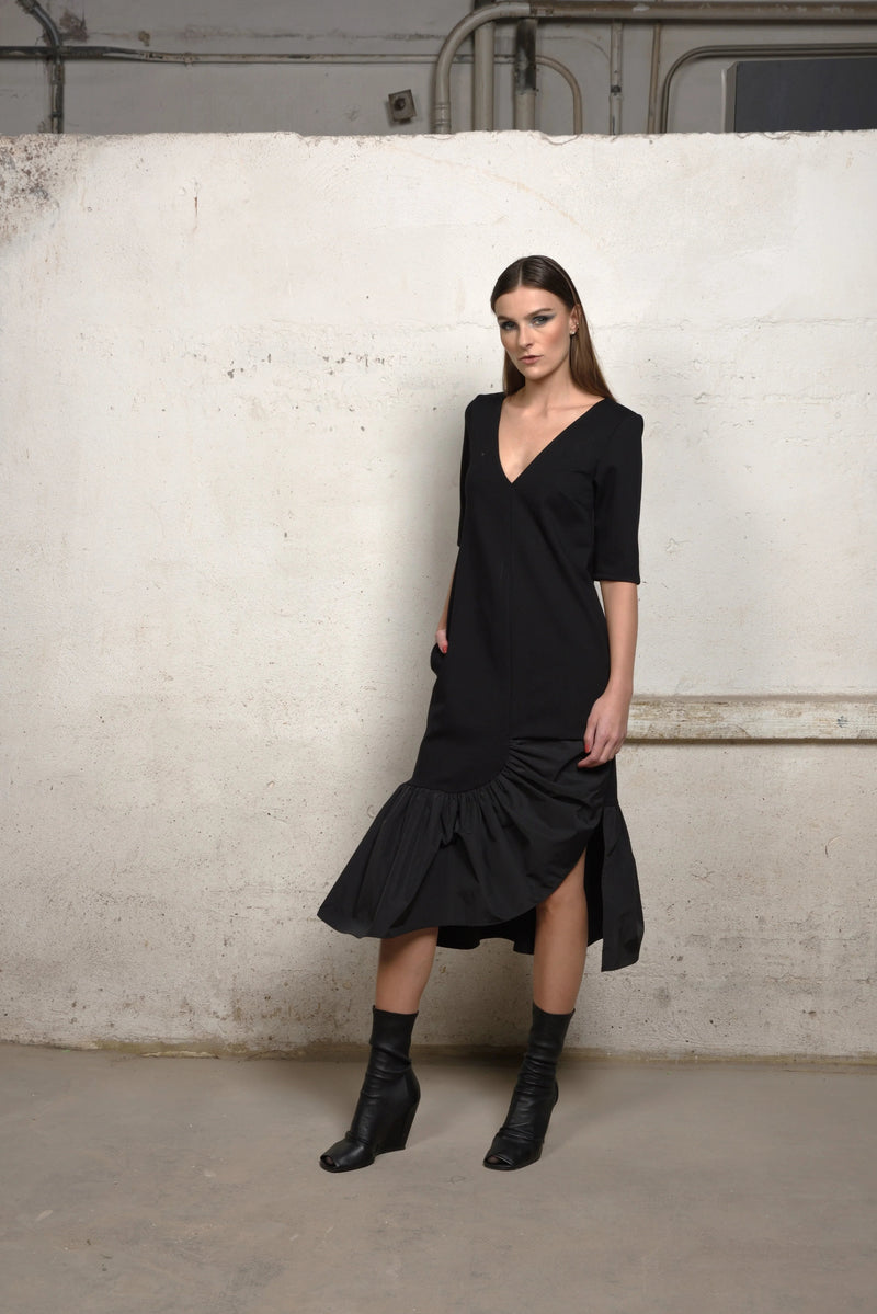 Simply Mila unbalance ruffle sweater dress in soft knit fabric, featuring ruffle details and a relaxed fit for modern women's style.
