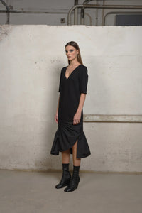 Side view of a SIMPLY MILA modern women's ruffle sweater dress with an unbalanced ruffle design, showcasing stylish knit fabric.