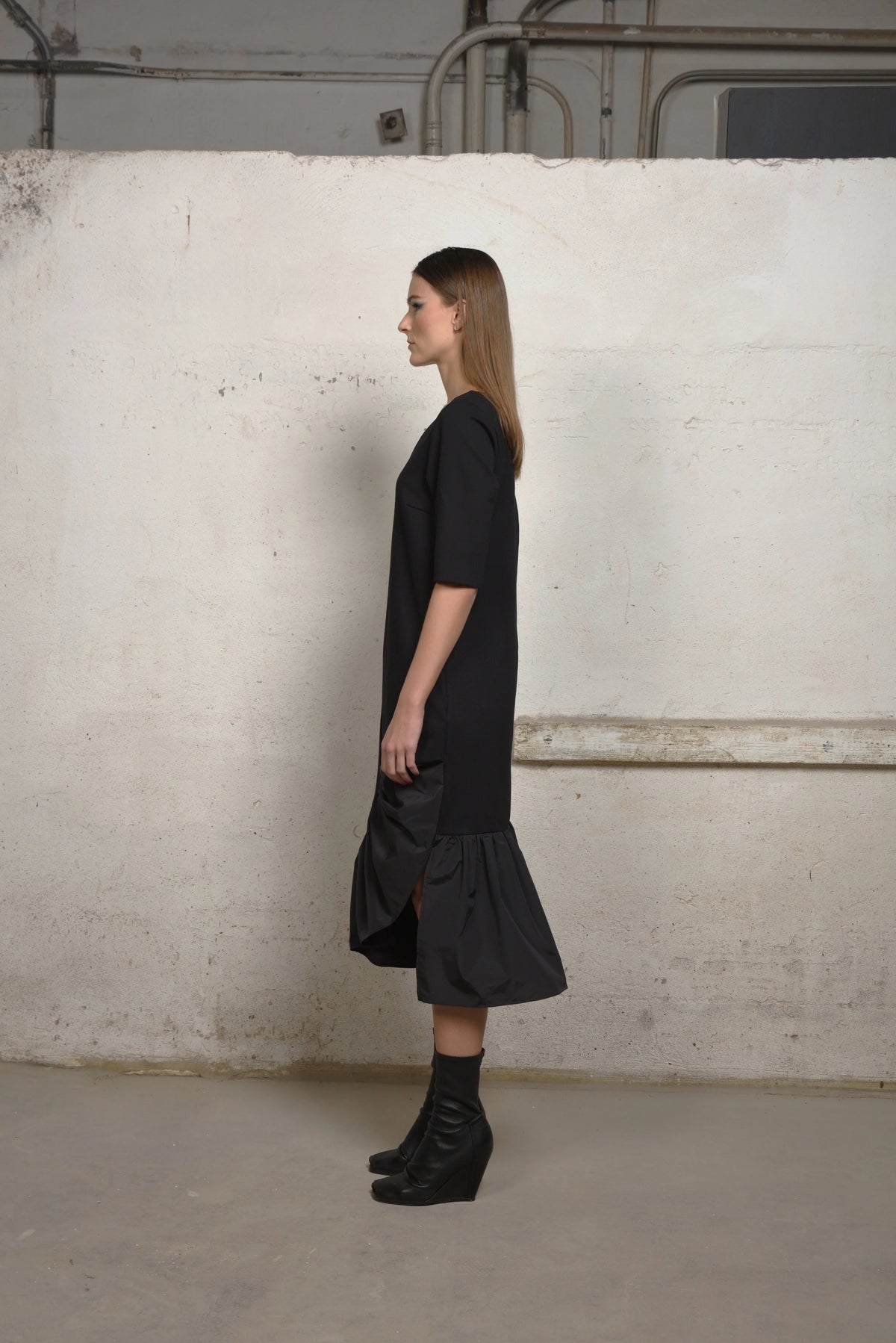 Side view of a SIMPLY MILA Unbalance Ruffle sweater dress featuring ruffled details and a modern women's clothing style.