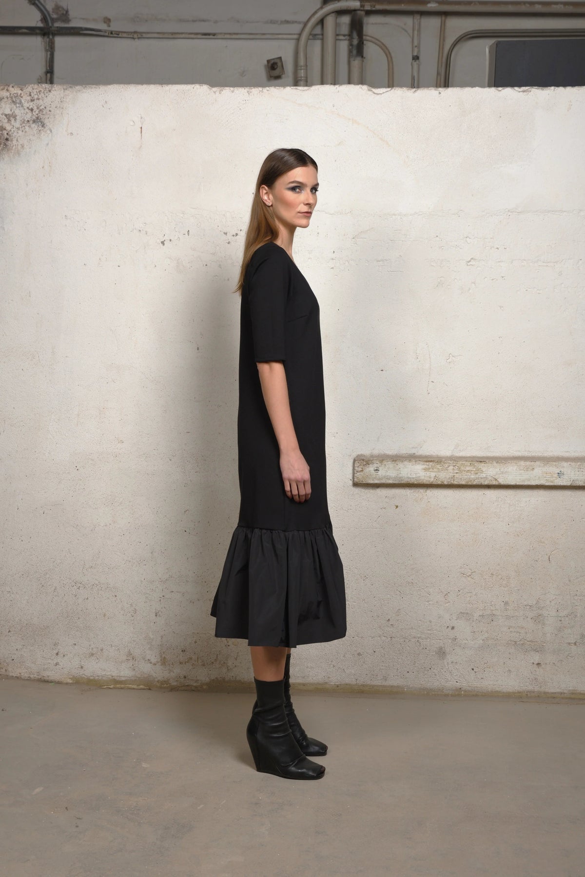 Side view of a simply styled unbalance ruffle sweater dress by SIMPLY MILA, featuring a relaxed fit and ruffle details.