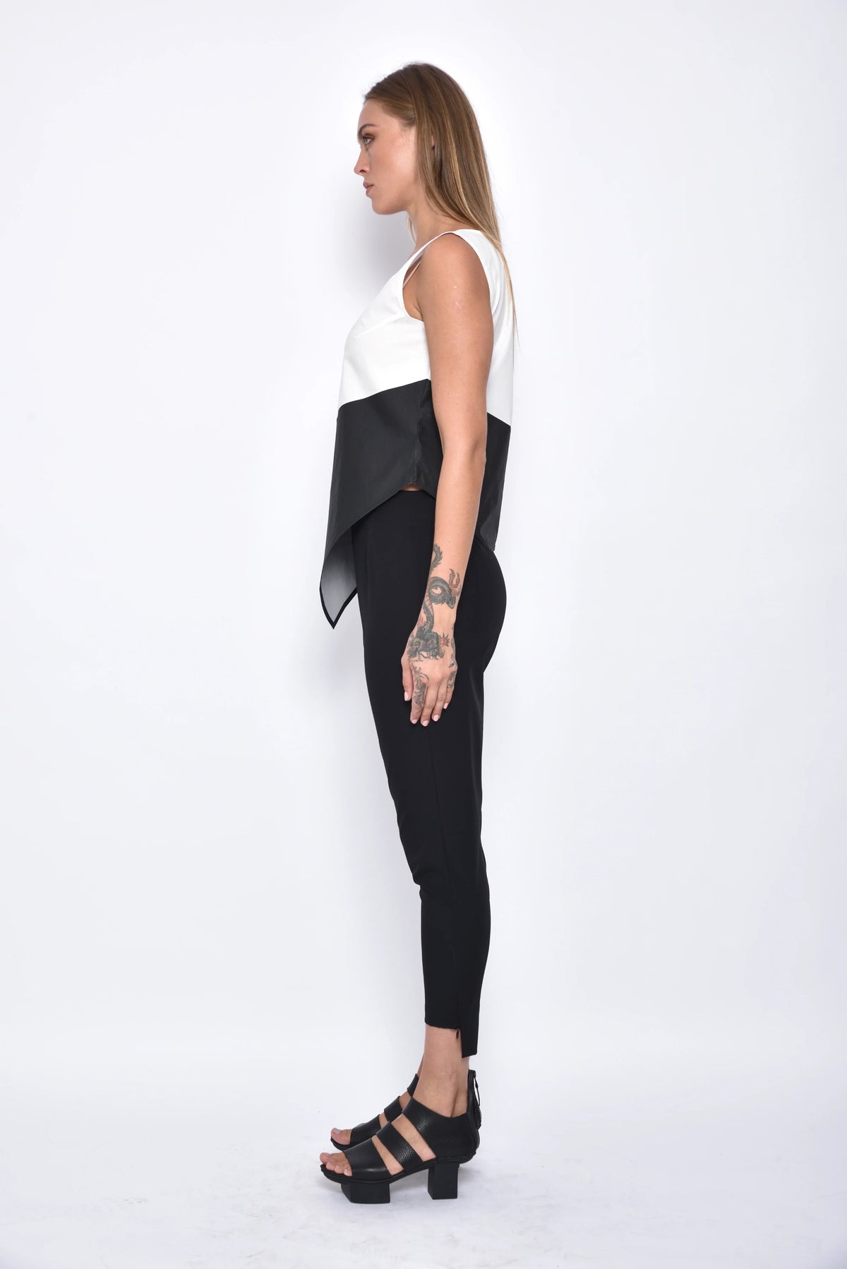 Side view of a modern women's uneven hem tank top by SIMPLY MILA, featuring a stylish, casual sleeveless design.