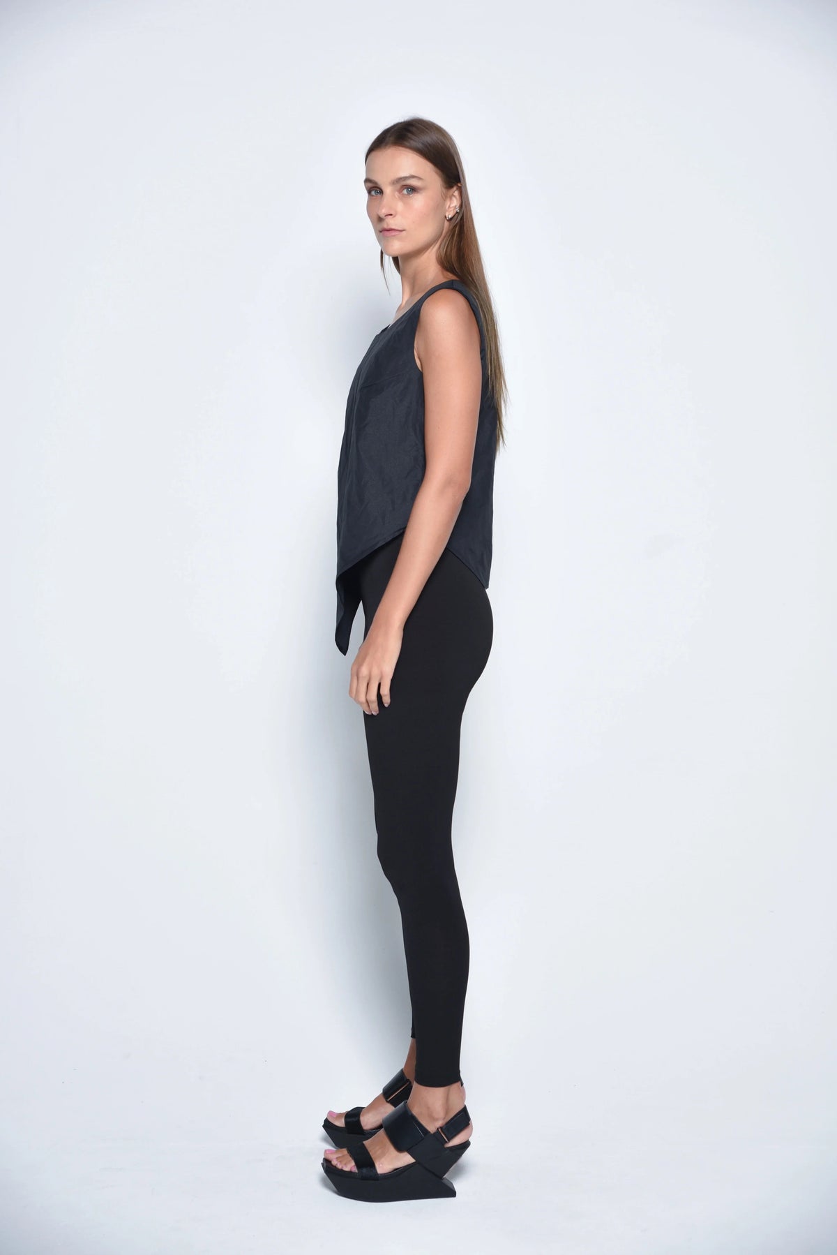 Black uneven hem tank top from SIMPLY MILA Modern Women's Clothing, featuring a stylish asymmetrical hem and sleeveless design.