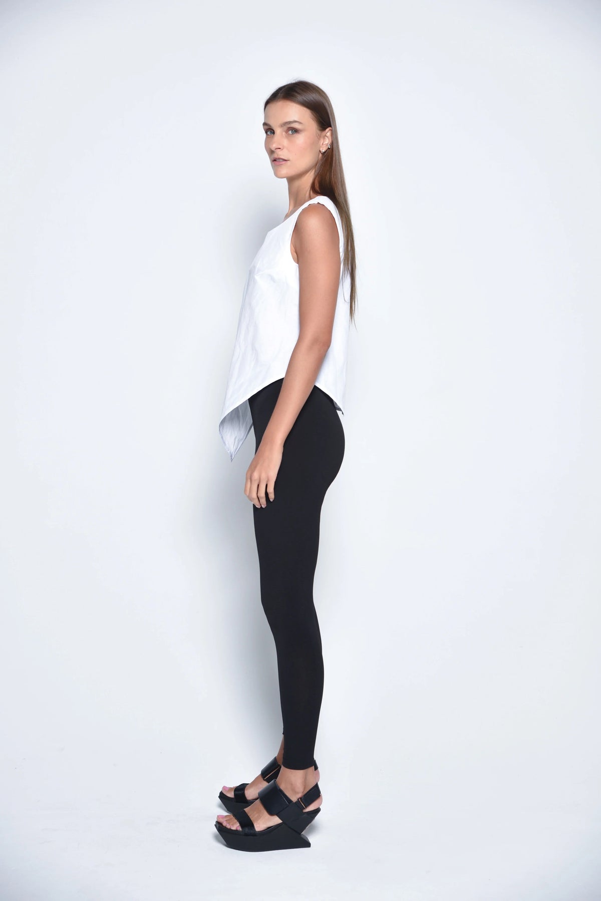 White uneven hem tank top by SIMPLY MILA, modern women's sleeveless tops with stylish asymmetrical hem detail.