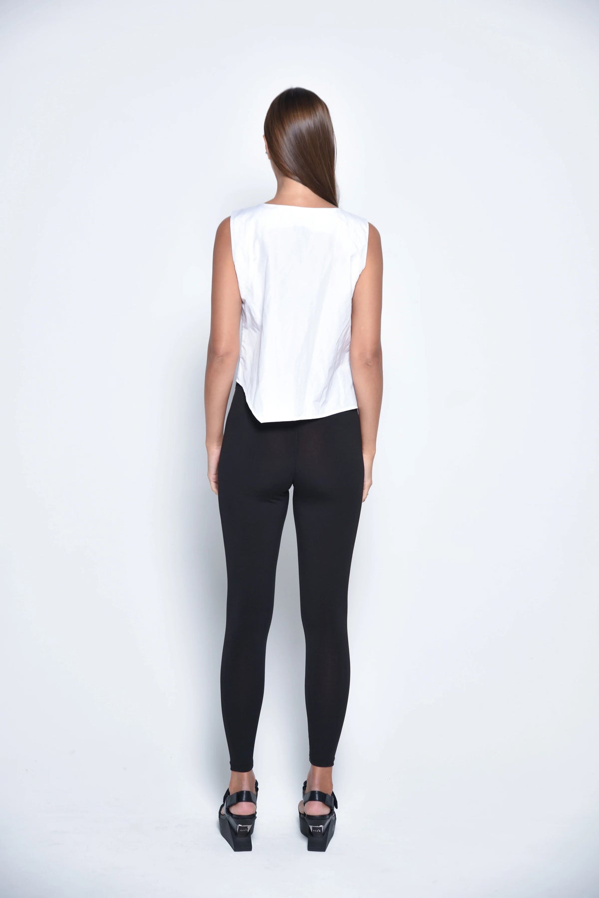 White uneven hem tank top from SIMPLY MILA Modern Women's Clothing, featuring a stylish, asymmetrical hem and sleeveless design.