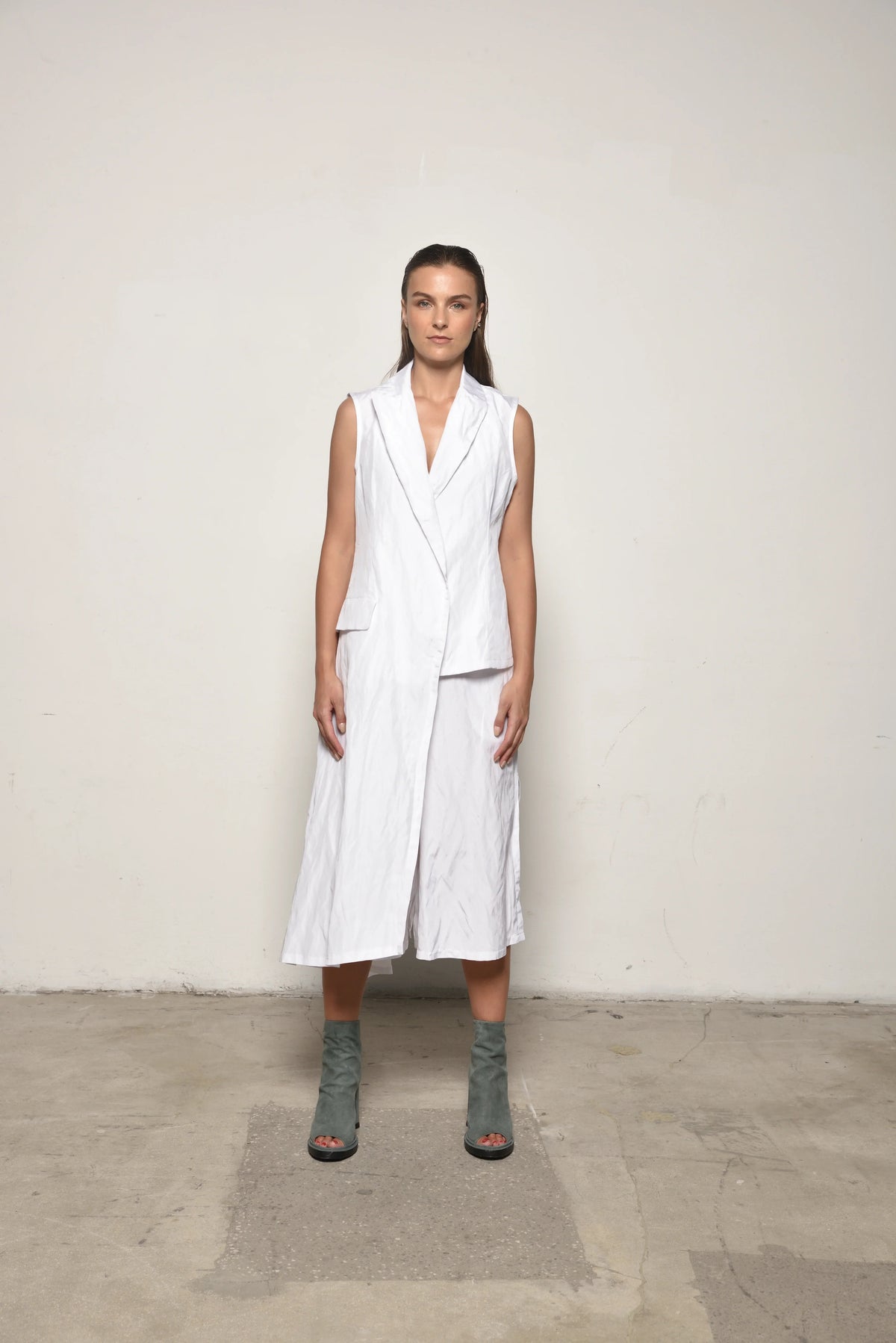 Front view of a white uneven vest by SIMPLY MILA Modern Women's Clothing, featuring asymmetrical hem and stylish design.