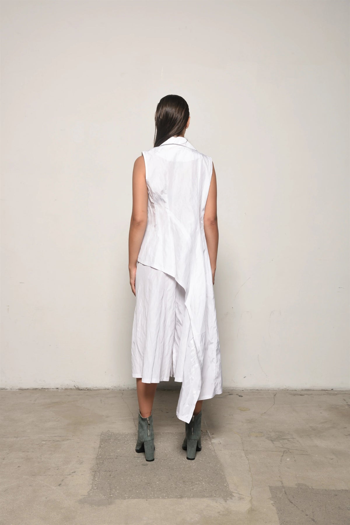 Back view of a white uneven vest by SIMPLY MILA, modern women's clothing, showcasing layered fabric and stylish design.