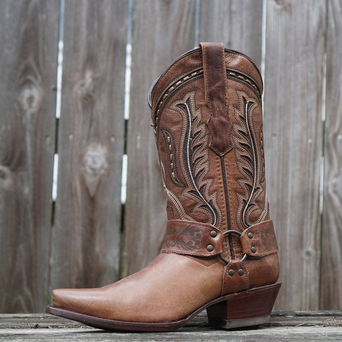 Brown leather women's harness cowgirl boots by Soto Boots with decorative harness straps and pointed toe design.