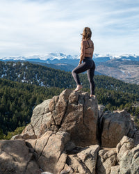 Empower Luxe leggings by Soul Fire Apparel Co displayed on a hanger, showcasing their sleek black fabric and high-waisted fit.