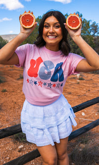 Pink USA graphic T-shirt from Sugar Stitch Wholesale, featuring a vibrant patriotic design on a soft cotton fabric.