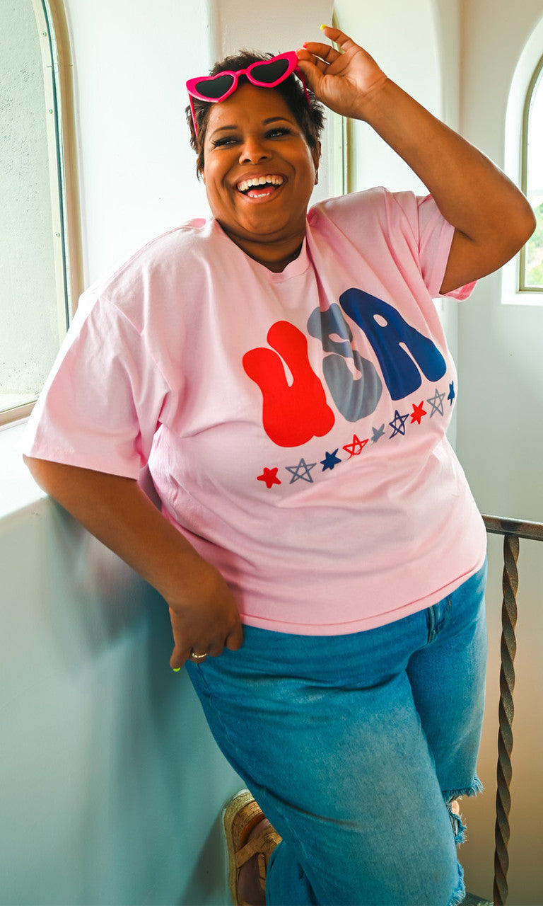 Pink USA graphic T-shirt by Sugar Stitch Wholesale, featuring bold patriotic design on soft cotton fabric.