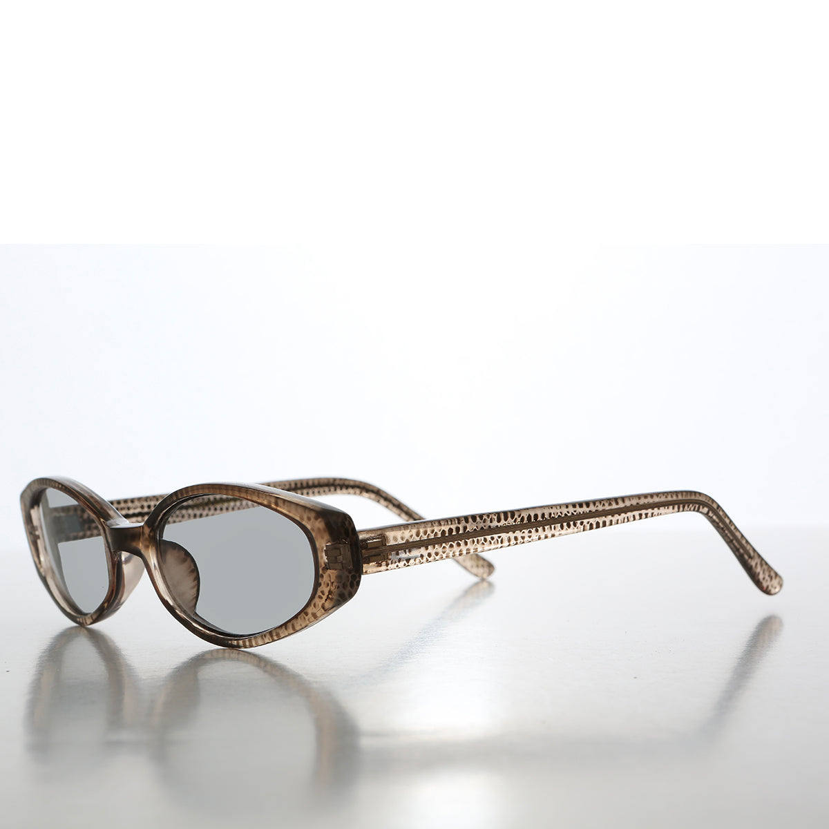 Retro 90s oval sunglasses with tinted lenses from Sunglass Museum, featuring a stylish vintage design.