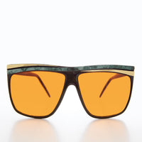 Women's 80s large sunglasses with orange lenses by Sunglass Museum, featuring bold frame and vibrant retro style.