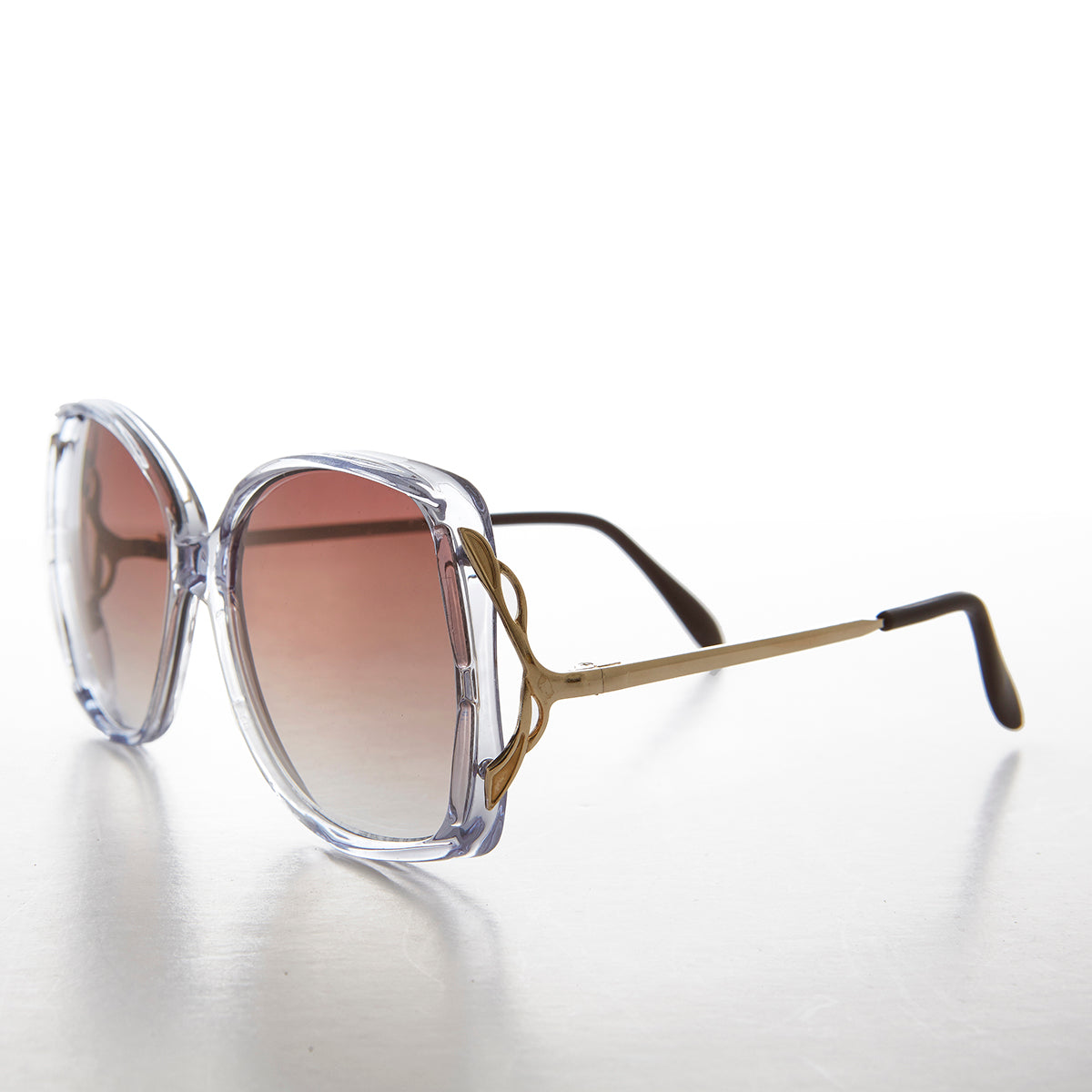 Large square women's sunglasses in gold with tinted lenses, stylish and trendy, by Sunglass Museum.