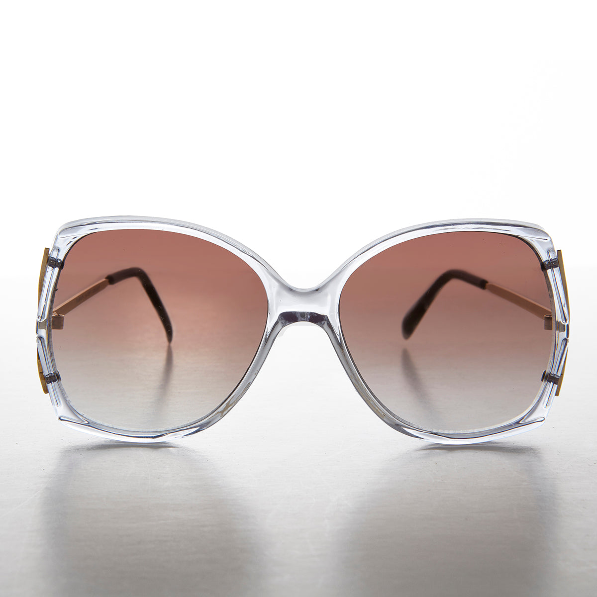 Large square women's sunglasses by Sunglass Museum with gold-tone frames and dark tinted lenses.