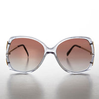 Large square women's sunglasses by Sunglass Museum with gold-tone frames and dark tinted lenses.