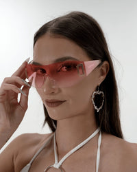 Neon pink shield sunglasses by SUSPEX Rave Outfits with bold, reflective lenses and a futuristic design on a white background.