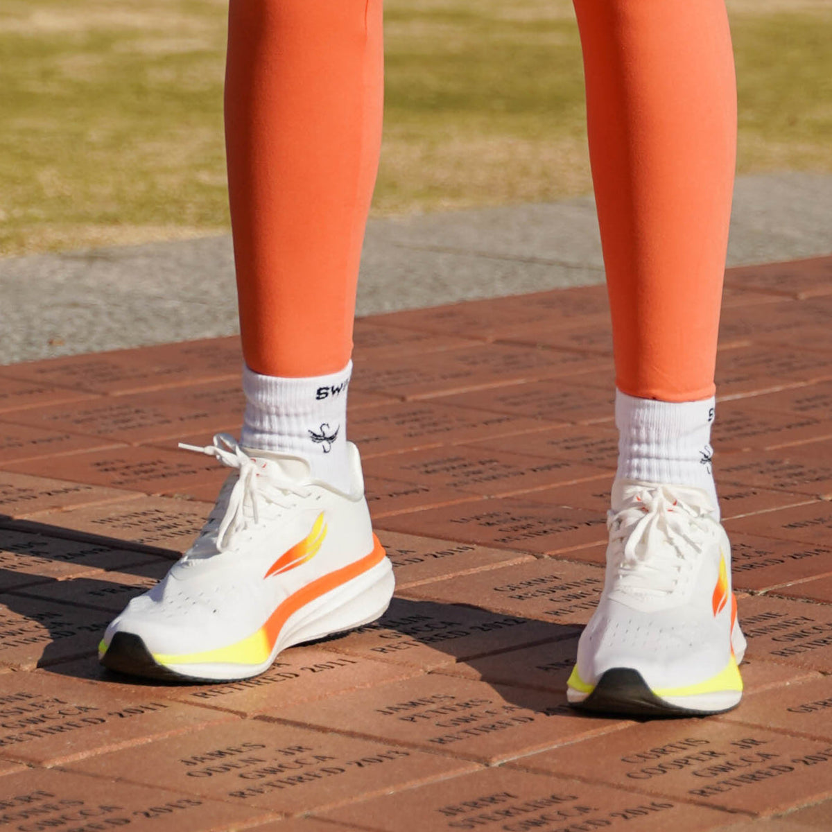White APUS women’s athletic shoes by Swift Running featuring a sleek design and comfortable fit for active wear.