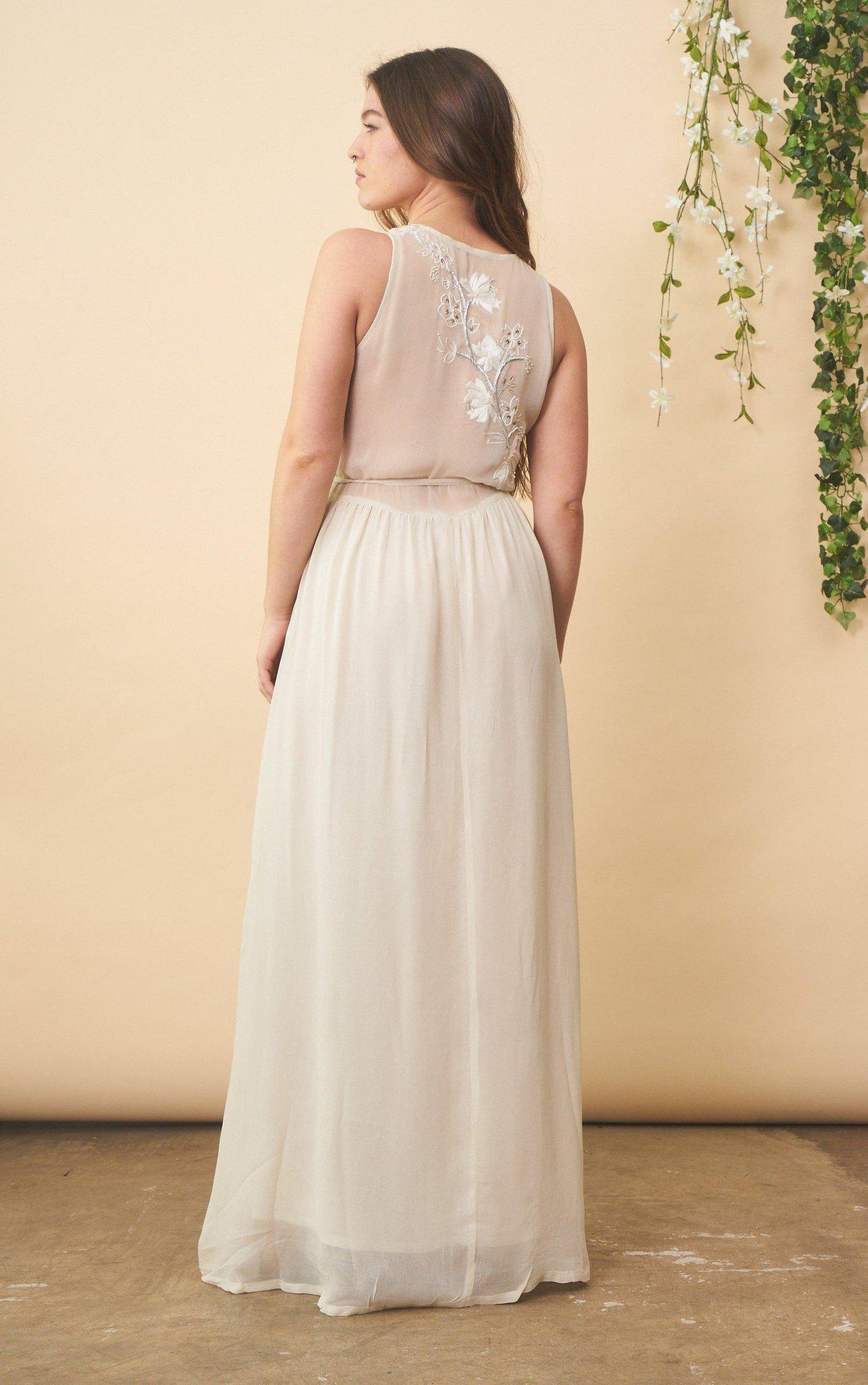 Cream floral embroidered wedding dress with silver accents by SymbologyClothing, featuring a flowing silhouette and intricate embroidery.