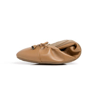 Talaria Flats premium caramel-colored shoes with a folded design, showcasing stylish and comfortable footwear.