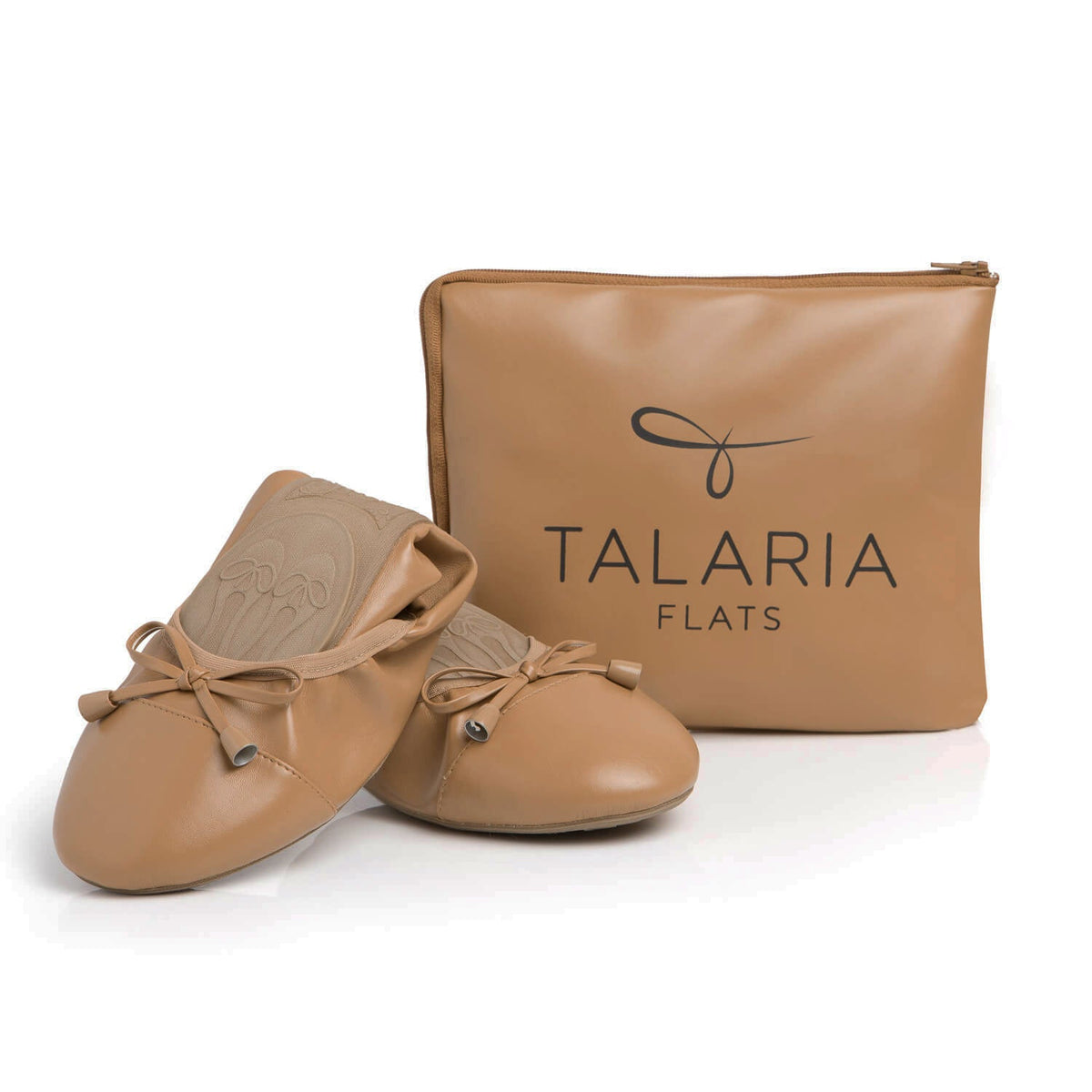 Talaria Flats caramel-colored shoes partially folded next to a matching bag, showcasing stylish and comfortable footwear.
