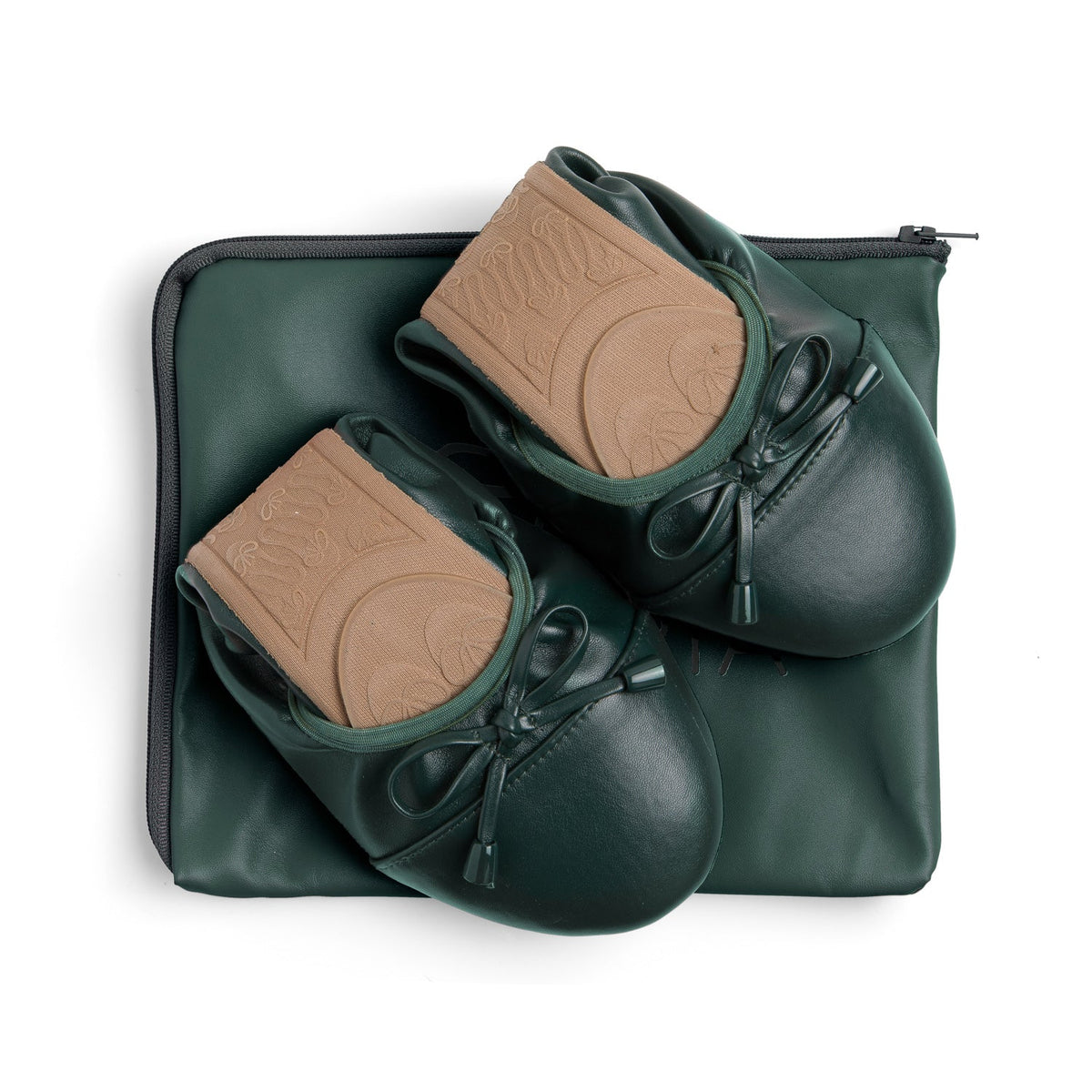 Green Talaria Flats shoes folded on a bag, showcasing the premium evergreen flats, a stylish and comfortable footwear option.