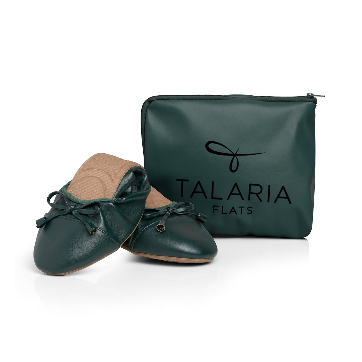 Green Talaria Flats shoes folded in front of a bag, showcasing the premium evergreen slip-on shoes for women.