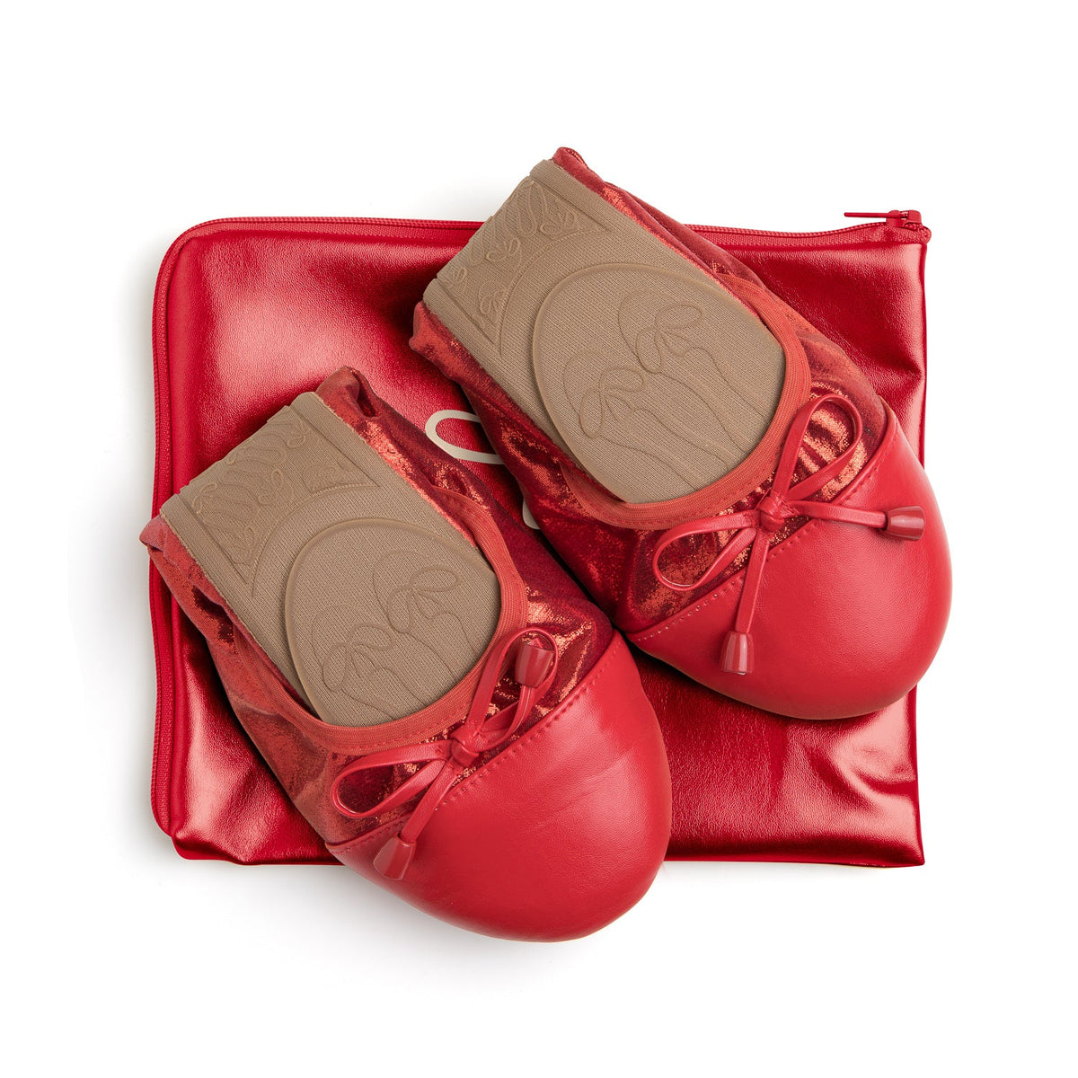 Red Talaria Flats shoes resting on a bag, showcasing the elegant Ruby Red Flats design and sleek style.