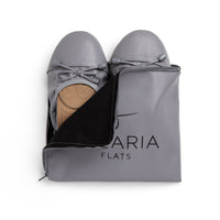 Talaria Flats premium stone grey shoes inside a bag, showcasing the stylish and comfortable design of the flats.