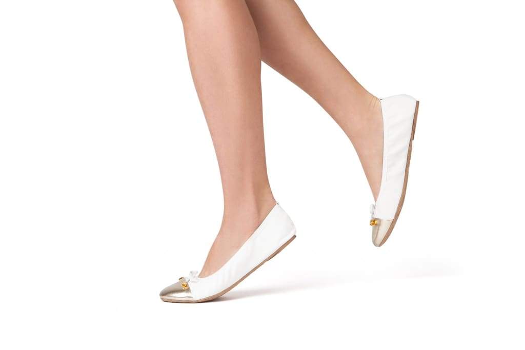 White Talaria Flats shoes with sleek, minimalist design and comfortable flat soles for stylish everyday wear.