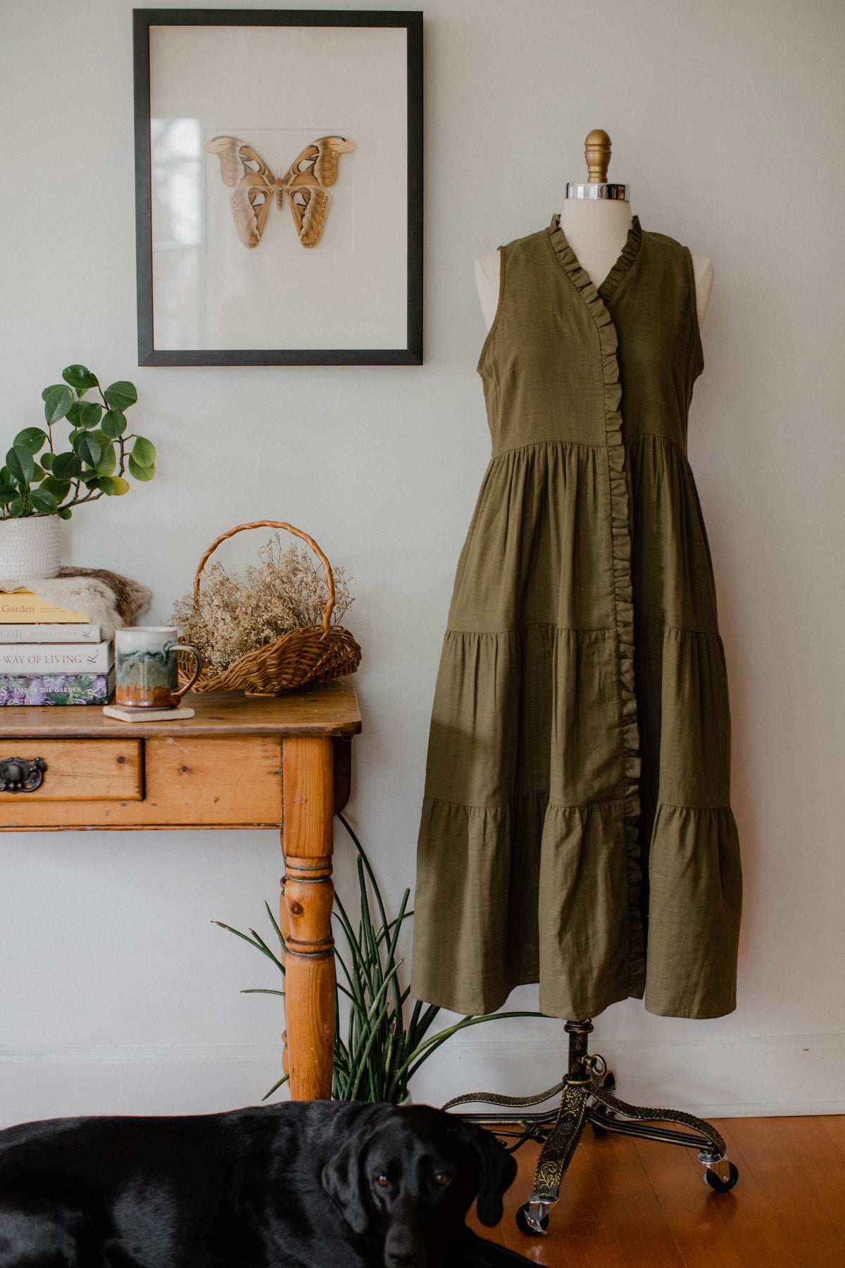 A cozy house dress from The Village Green with a soft moss green fabric, displayed on a dress form.