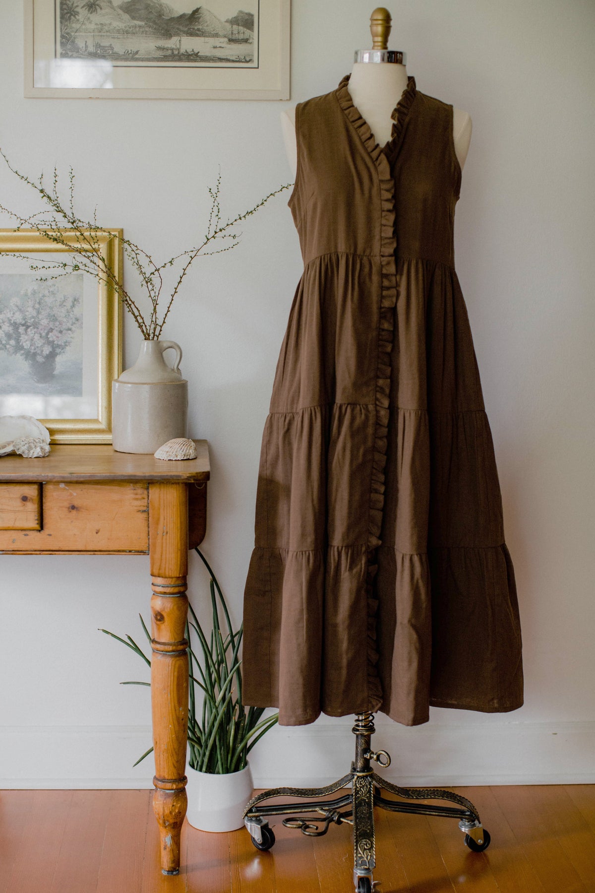 Brown The House Dress by The Village Green, featuring a relaxed fit and casual style, displayed on a hanger against a plain background.