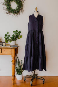 Navy blue The Village Green house dress displayed on a hanger, featuring a comfortable, relaxed fit and casual design.