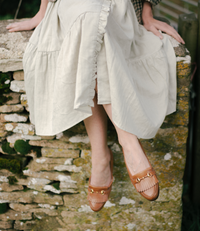 The Village Green house dress with floral print, featuring a relaxed fit and short sleeves, displayed on a hanger.