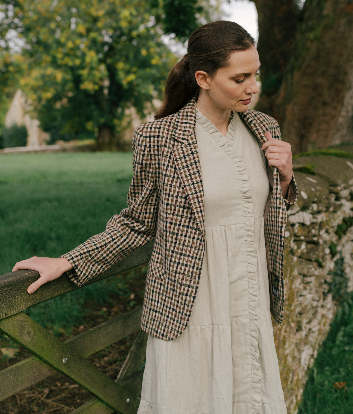 A woman wearing The Village Green The House Dress with a relaxed fit, featuring a soft fabric and knee-length design.