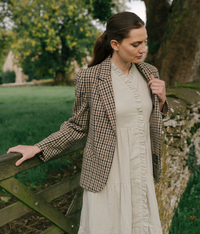 A woman wearing The Village Green The House Dress with a relaxed fit, featuring a soft fabric and knee-length design.