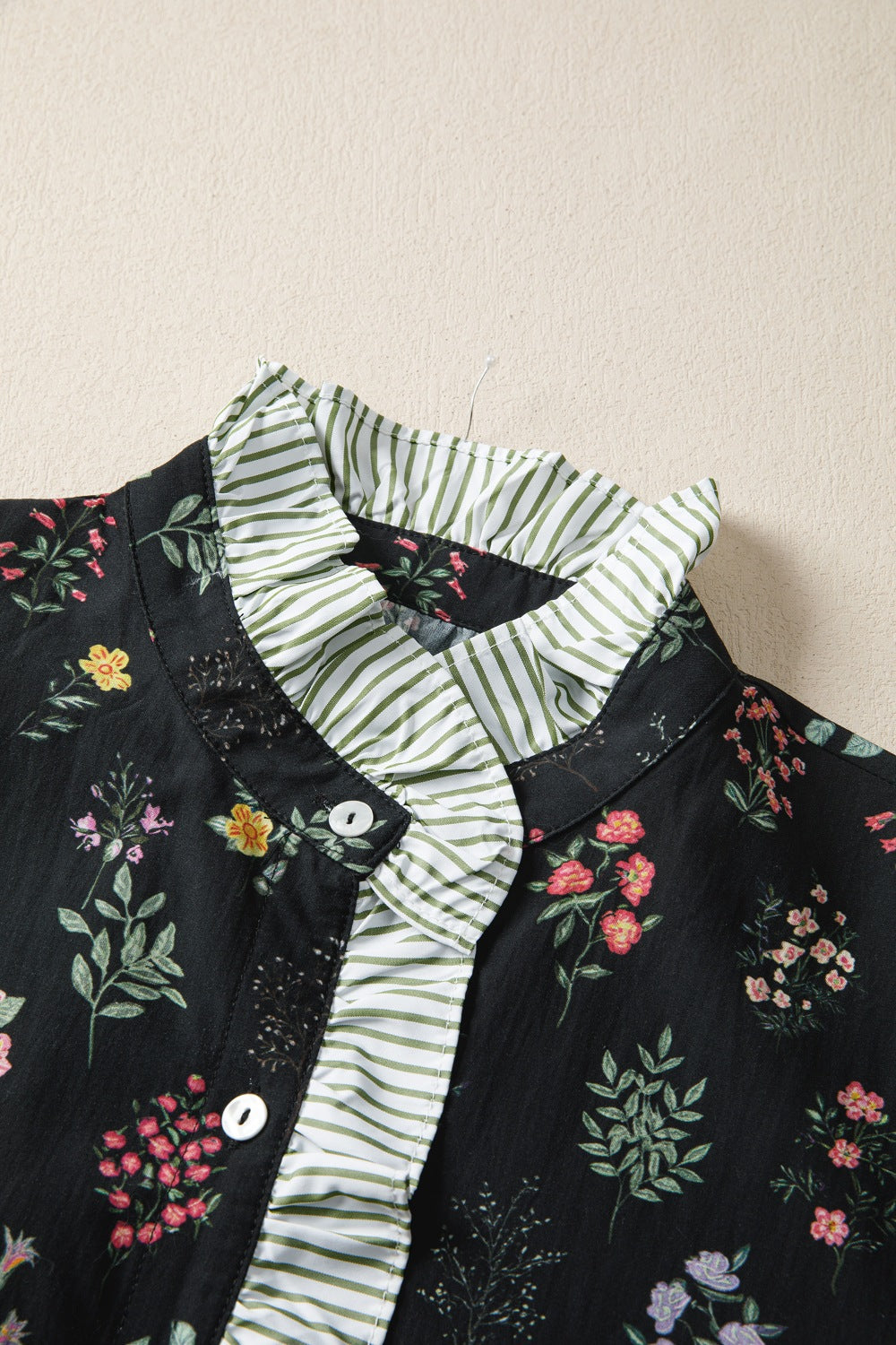 Black floral short sleeve shirt with contrast frilled trim from Trendsi, featuring a stylish and feminine design.