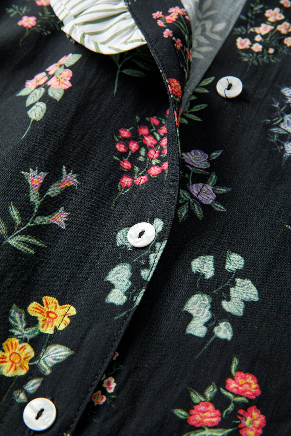 Black floral short sleeve shirt with contrast frilled trim from Trendsi, featuring a stylish, feminine design and floral pattern.