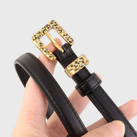 Black skinny leather belt with silver buckle from Trendsi, featuring sleek design and adjustable strap for a chic, modern look.