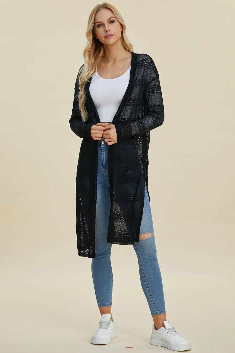 Black Trendsi Double Take open front longline cardigan hanging on a rack, showcasing its relaxed fit and draped style.