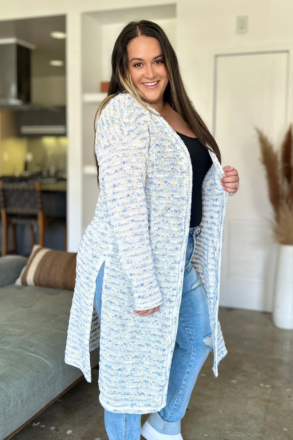 Black Trendsi Double Take open front longline cardigan displayed on a hanger, showcasing its relaxed fit and lightweight knit fabric.