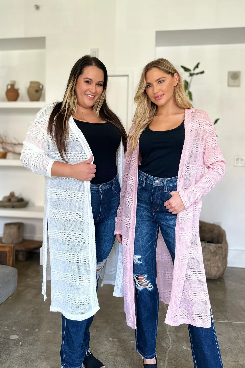 Black Trendsi Double Take full-size open front longline cardigan draped on a hanger, showcasing its relaxed fit and cozy style.