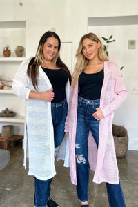 Black Trendsi Double Take full-size open front longline cardigan draped on a hanger, showcasing its relaxed fit and cozy style.