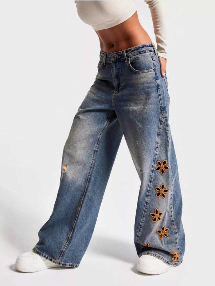 Blue floral embroidered wide-leg jeans by Trendsi featuring intricate embroidery and relaxed fit, stylish casual denim pants.